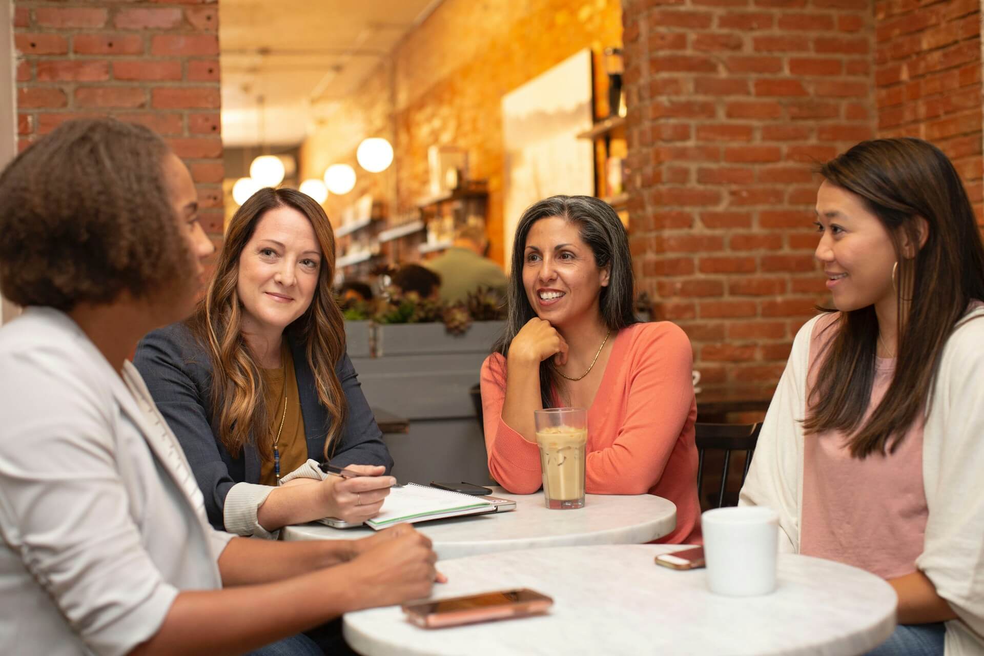 Group of adult ladies siting around a table and talking